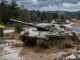 Kettenfahrzeug beim Panzerfahren auf einer Gelaendestrecke in Deutschland