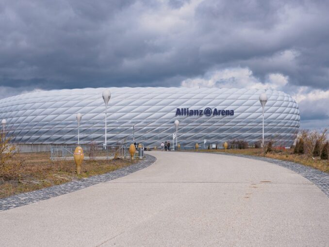 Allianz Arena in München von vorn mit Zuweg und bewölktem Himmel