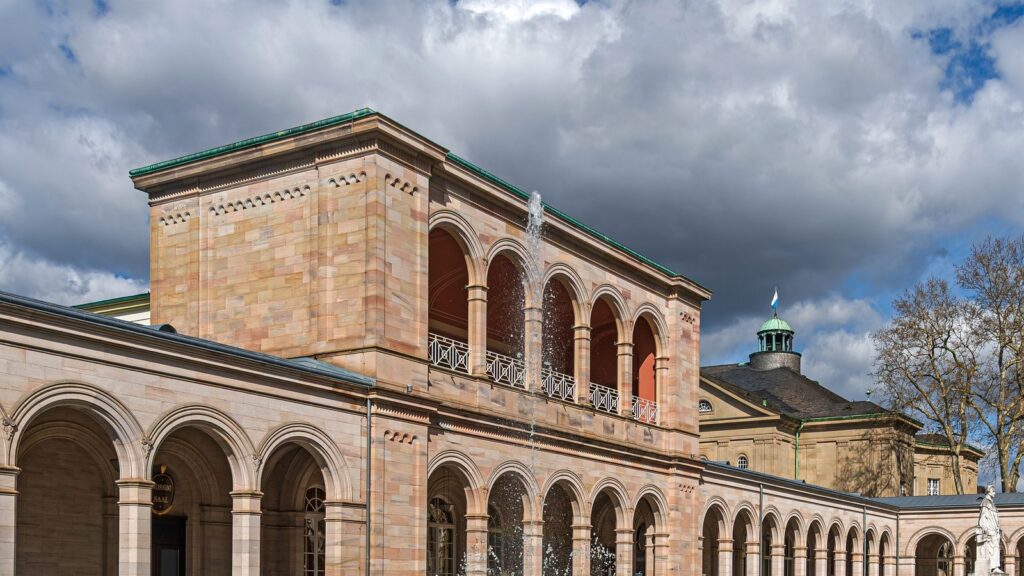 Arkadenbau in Bad Kissingen mit Springbrunnen und blühenden Tulpenbeeten