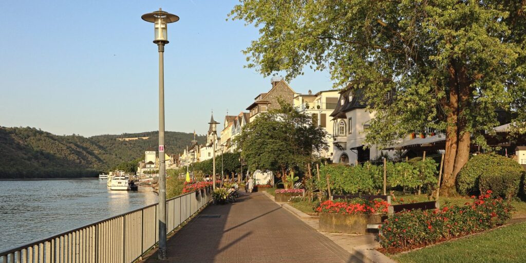 Rheinpromenade in Boppard mit Laternen, Blumenbeeten und Ausflugsschiff am Ufer