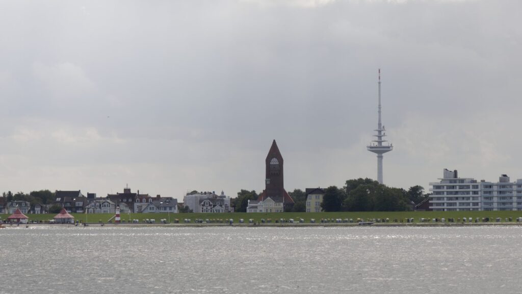 Strandpromenade von Cuxhaven mit Strandkörben, Kirchturm und Funkturm vom Wasser aus