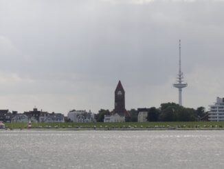 Strandpromenade von Cuxhaven mit Strandkörben, Kirchturm und Funkturm vom Wasser aus