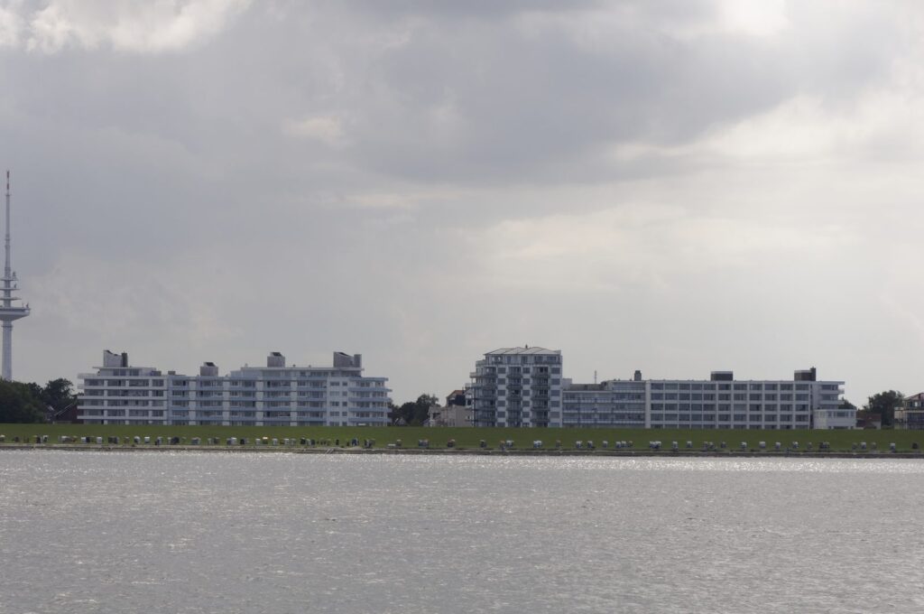 Lange Reihe von Strandkörben auf dem Deich vor den Häusern von Duhnen