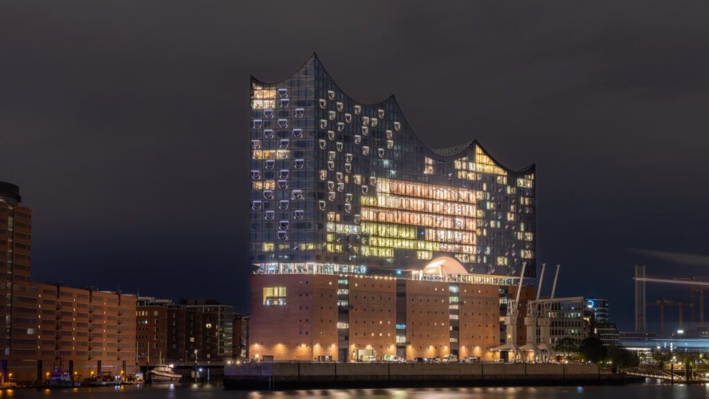 Beleuchtete Elbphilharmonie bei Nacht vom Südufer der Elbe aus gesehen