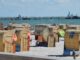 Strandkörbe am Grömitzer Sandstrand mit der Seebrücke im Hintergrund bei Sonnenschein