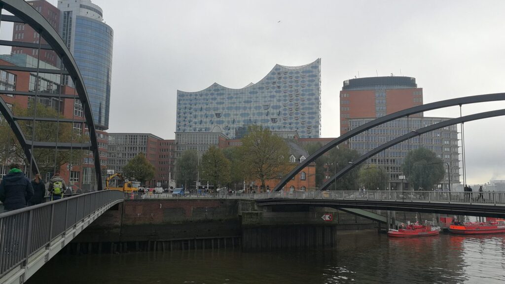 Elbphilharmonie mit geschwungenem Glasdach über dem Backsteinsockel des Kaispeichers A