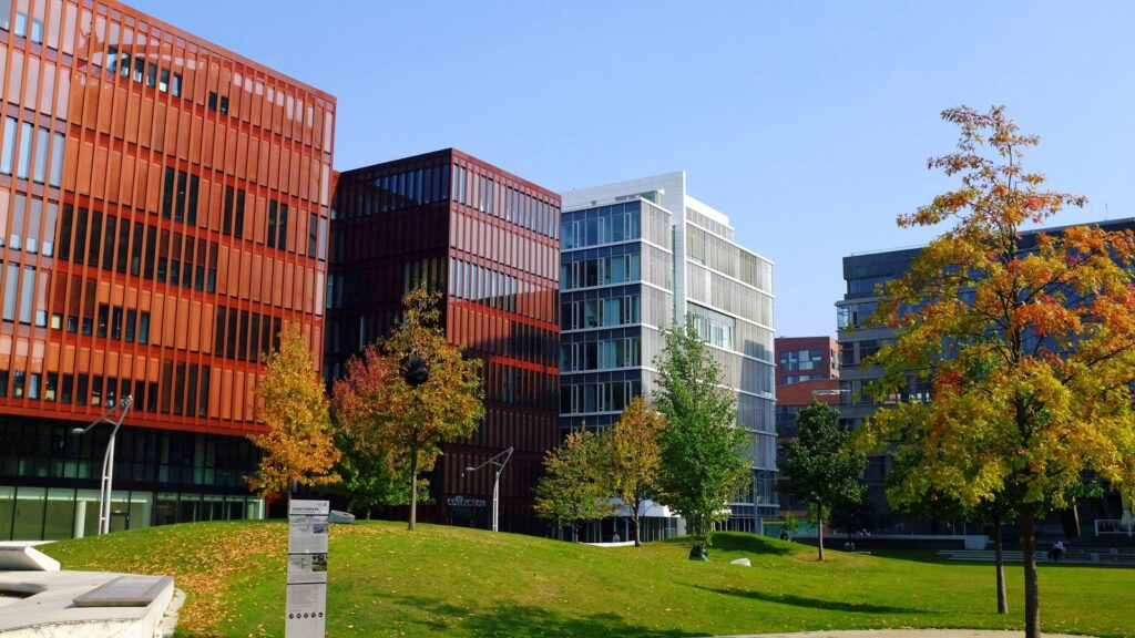 Sandtorpark in der HafenCity mit Rasenfläche und farbigen Neubaufassaden im Herbst