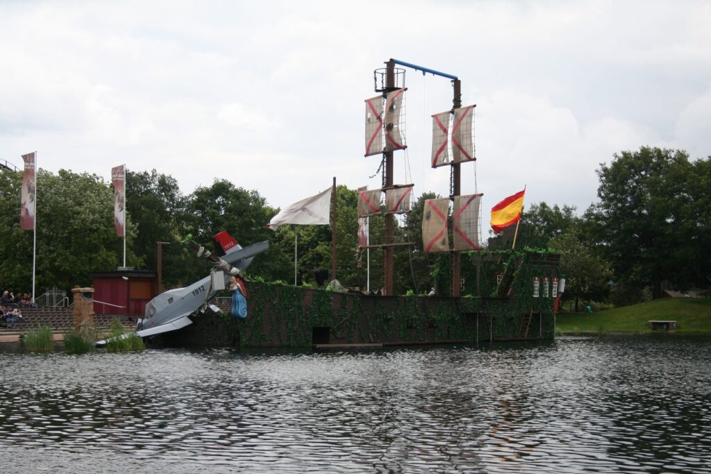 Piratenschiff-Kulisse mit abgestürztem Flugzeug am Wasser im Heide Park