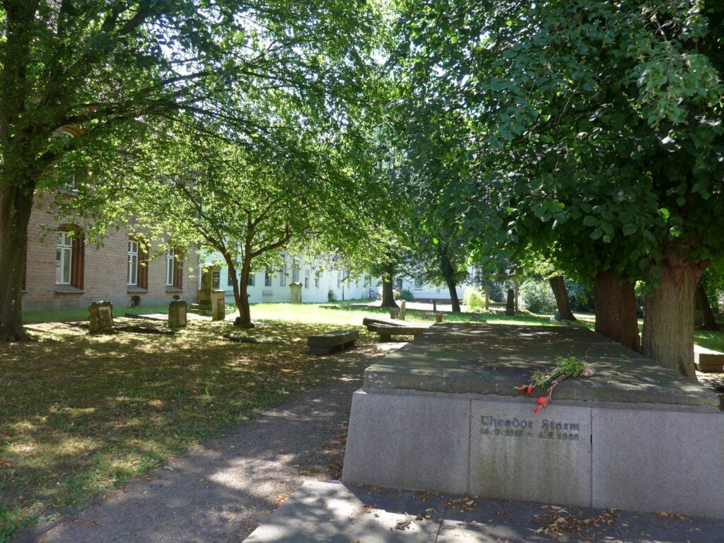 Familiengruft von Theodor Storm unter alten Bäumen auf dem Friedhof St. Jürgen