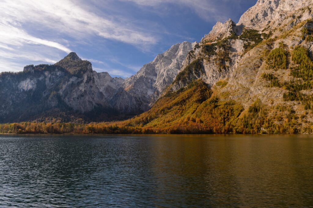 Herbstlich gefärbte Ufer des Königssees unter den Felswänden der Berchtesgadener Alpen