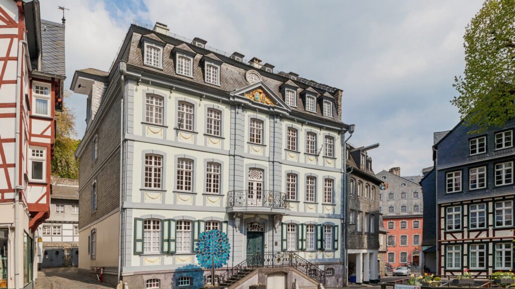 Barockes Bürgerhaus und Fachwerkhäuser am kopfsteingepflasterten Platz in der Altstadt von Monschau
