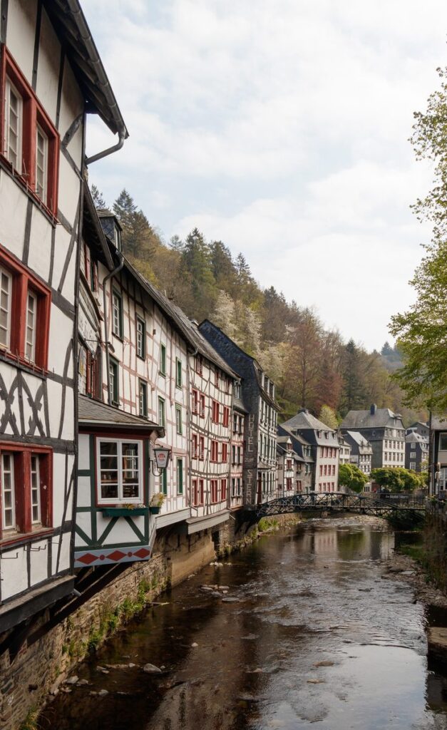 Fachwerkhäuser mit Schieferdächern stehen dicht an der Rur in Monschau
