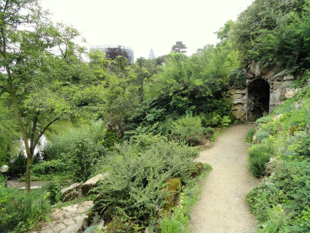 Gartenweg am Felsengarten des Palmengartens mit Frankfurter Hochhäusern im Hintergrund
