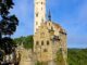 Schloss Lichtenstein mit weißem Bergfried und Zugbrücke auf dem Felsen der Schwäbischen Alb