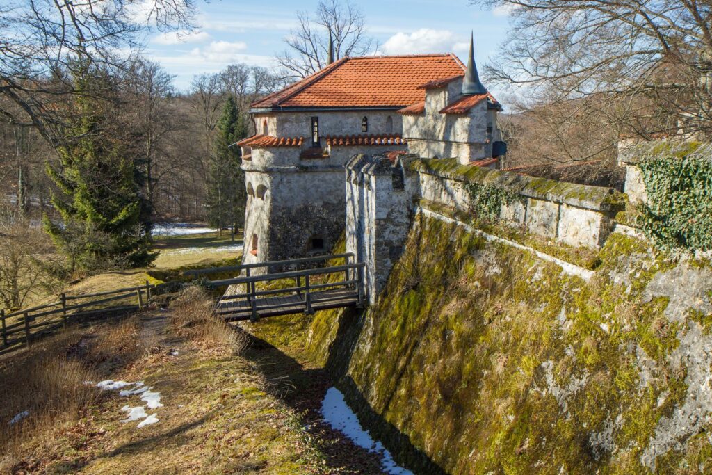Burggraben mit Holzbrücke und Torbau vor dem Schloss Lichtenstein im Winter