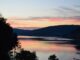Abendrot über dem Schluchsee mit bewaldeten Schwarzwaldhöhen und dem Ort am Ufer