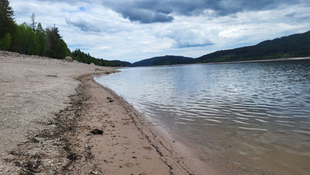 Breiter Sandstrand am Schluchsee bei Aha mit abgesenktem Wasserstand im Frühjahr