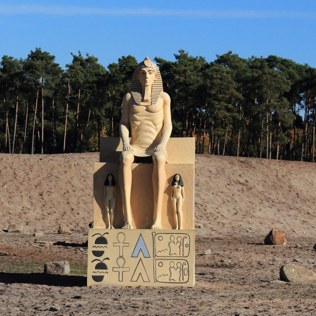 Nachbildung einer sitzenden Pharaonenstatue auf einem Sandhügel im Serengeti-Park