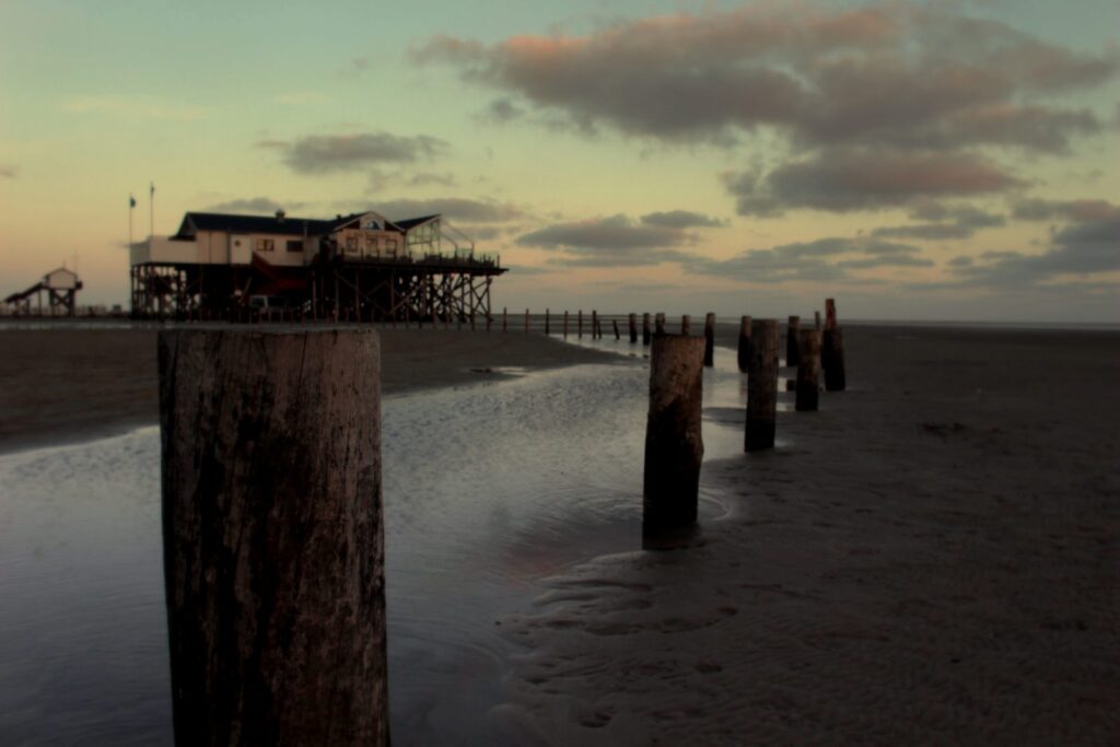 Pfahlbau auf hohen Holzpfählen am Strand von St. Peter-Ording im Abendlicht