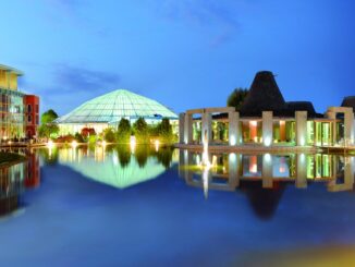 Therme Erding in der Abenddämmerung mit Glaskuppel, Saunadörfern und Badesee