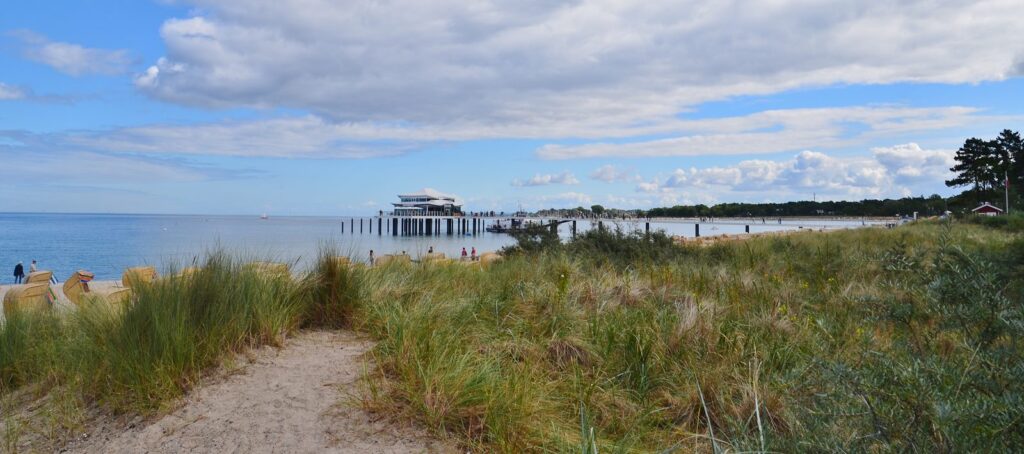 Strand von Timmendorfer Strand mit Dünengras, Strandkörben und dem Teehaus auf der Seebrücke