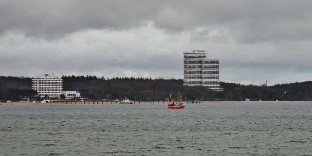 Timmendorfer Strand von der Ostsee aus mit Hotelhochhäusern und Fischkutter im Winter