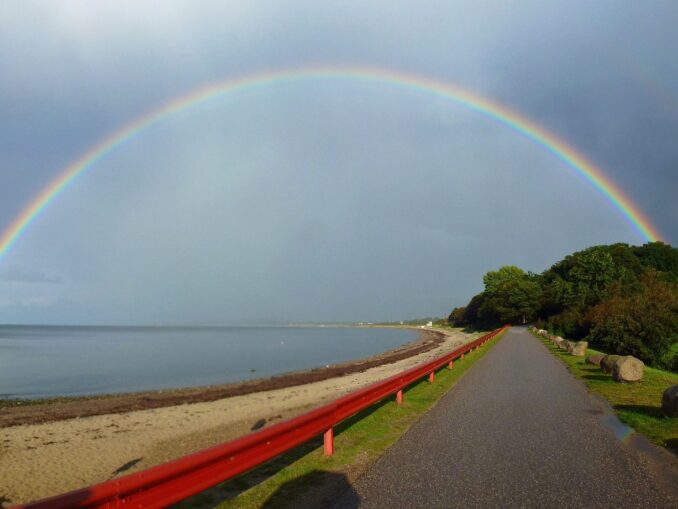 Regenbogen über der Ostsee am Weissenhäuser Strand mit Sandstrand und Küstenweg