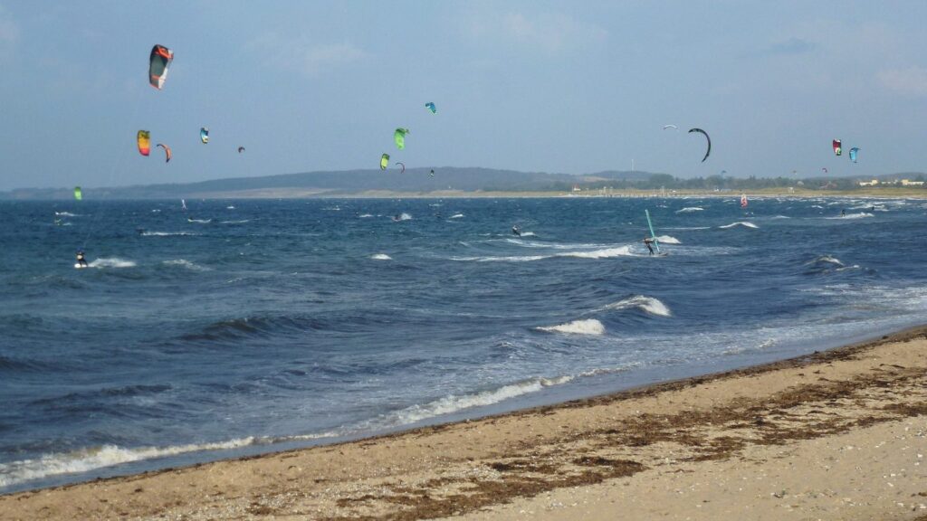 Kite- und Windsurfer vor dem breiten Sandstrand von Weissenhäuser Strand an der Ostsee
